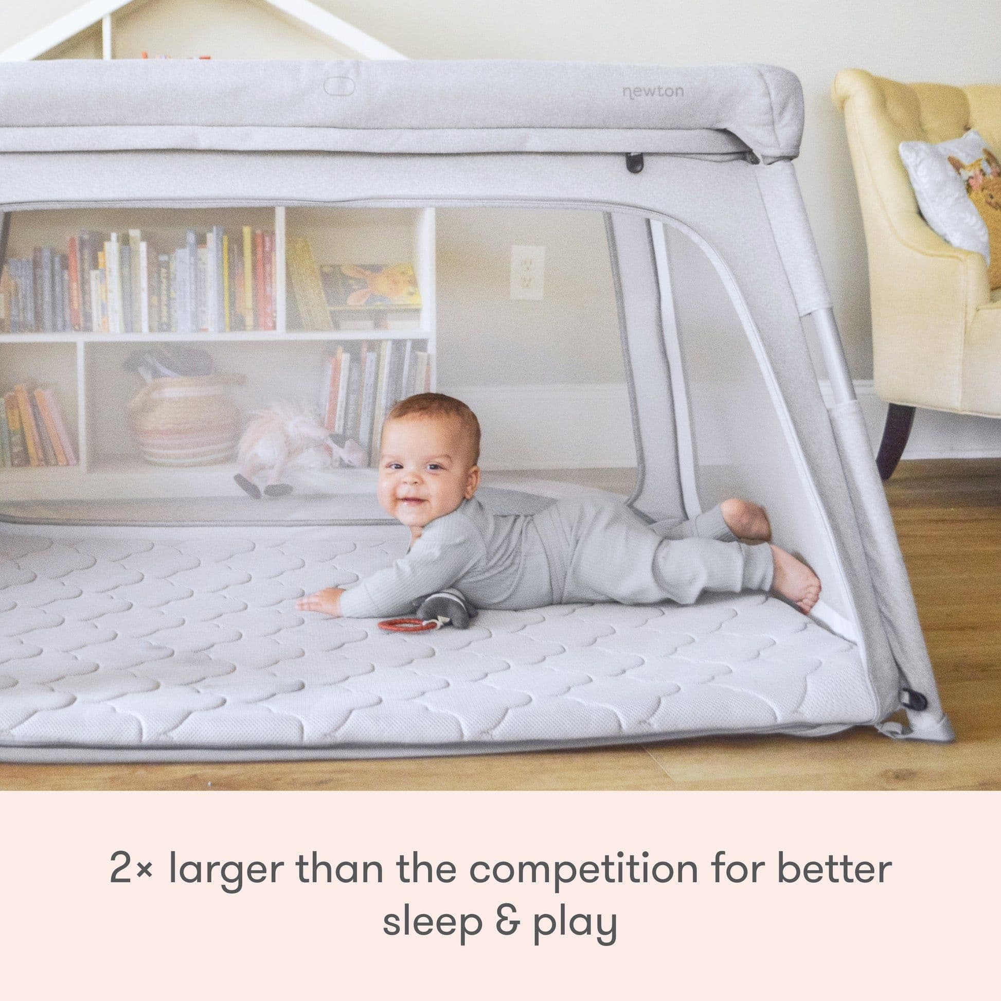 Baby asleep in a portable travel crib play yard with a firm fitted mattress