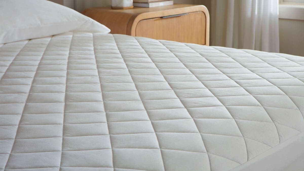 Organic cotton mattress protector on a neatly made bed in a serene bedroom